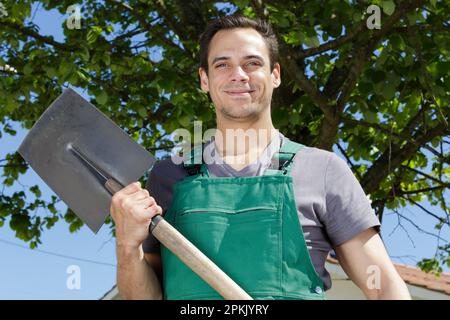 Un Fermier Avec Une Pelle Creuse Le Sol Dans Le Jardin Photo stock - Image  du expression, masculin: 226518138