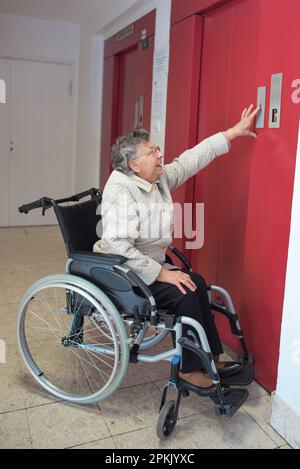 femme âgée en fauteuil roulant seule se trouvant dans l'ascenseur Banque D'Images