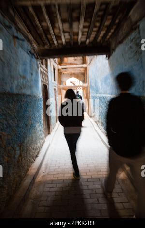 Les gens marchent dans une allée couverte à Fès Medina Maroc Banque D'Images