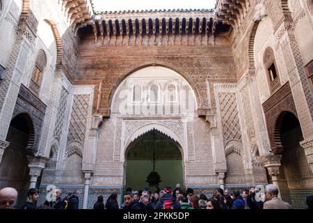 Les gens se rassemblent dans la cour d'Al-Attarine Madrasa à Fès Maroc Banque D'Images