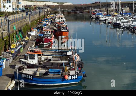 Petits bateaux de pêche colorés et équipement de pêche sur un ponton à Brighton Marina avec des bateaux à voile en arrière-plan. Banque D'Images