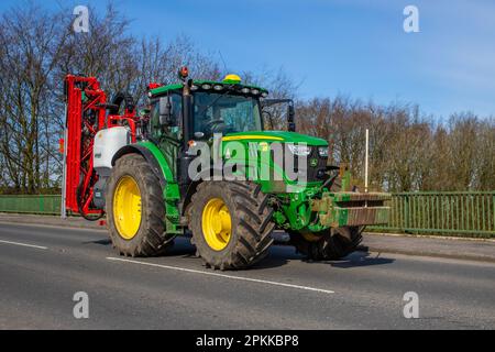 Tracteur JOHN DEERE 6155R avec pulvérisateur BARGAM; traversée du pont autoroutier dans le Grand Manchester, Royaume-Uni Banque D'Images