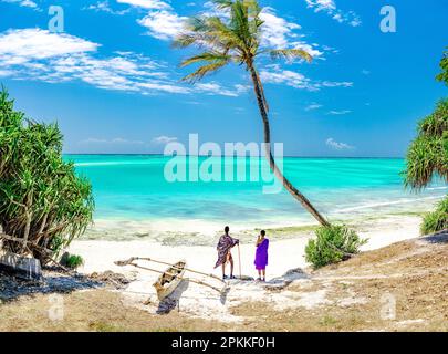 Homme et femme de la tribu Maasai admirant le lagon turquoise sous un palmier, Zanzibar, Tanzanie, Afrique de l'est, Afrique Banque D'Images