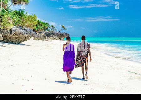 Couple de guerriers de Maasai appréciant la marche sur la plage exotique, Zanzibar, Tanzanie, Afrique de l'est, Afrique Banque D'Images