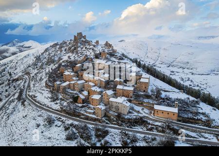 Vue aérienne en hiver du village médiéval enneigé de Rocca Calascio avec le château entouré de nuages au crépuscule, Rocca Calascio Banque D'Images