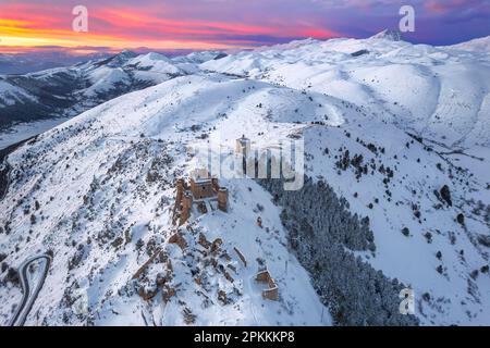 Vue aérienne en hiver du château de Rocca Calascio couvert de neige et de l'église Santa Maria della Pieta Banque D'Images