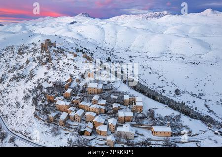 Vue aérienne en hiver du village médiéval enneigé de Rocca Calascio avec le château et le ciel rose au coucher du soleil, Rocca Calascio Banque D'Images