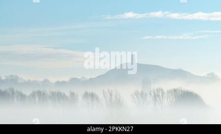 St. La tour de Michael sur Glastonbury Tor au-dessus de la tour de St. Église Jean-Baptiste le matin d'une matinée brumeuse en hiver, Glastonbury, Somerset, Angleterre Banque D'Images
