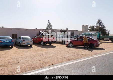 Un parking dans une station service à côté d'une autoroute dans le désert en Egypte Banque D'Images