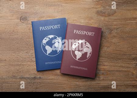 Différents passeports internationaux sur table en bois, plat Banque D'Images