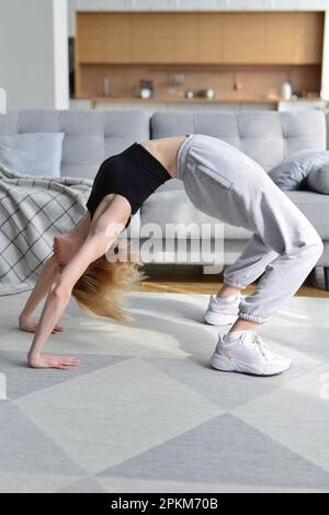 La femme effectue un exercice de pont à la maison Banque D'Images