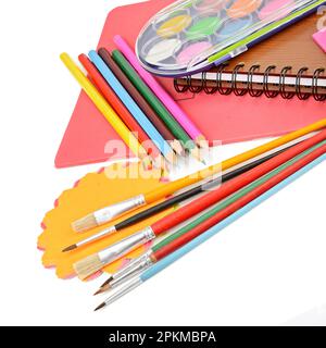 Crayons de couleur, peintures, carnets et autres articles de papeterie isolés sur fond blanc Banque D'Images