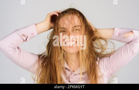 Mauvais poils le jour. Jeune femme aux cheveux longs et abîmés. Soins capillaires. Femme ayant de mauvais cheveux désordonnés et emmêlés. Modèle féminin avec cheveux secs non brossés. Banque D'Images