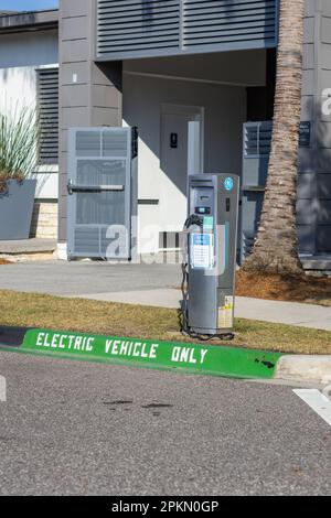 Poste de charge de véhicule électrique avec place de stationnement et panneau vert peint sur la route « véhicule électrique uniquement ». Prise dans la région de Lake Nona, Floride Banque D'Images