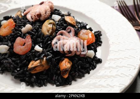 Délicieux risotto noir aux fruits de mer servis sur l'assiette, en gros plan Banque D'Images