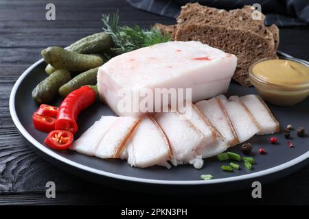 Fatback de porc aux épices, pain de seigle et concombres marinés sur l'assiette, gros plan Banque D'Images