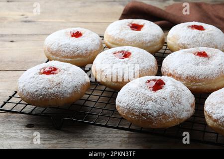 Beaucoup de délicieux beignets avec de la gelée et du sucre en poudre sur une table en bois Banque D'Images