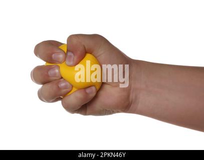 Homme pressant le ballon de stress jaune sur fond blanc, gros plan Banque D'Images