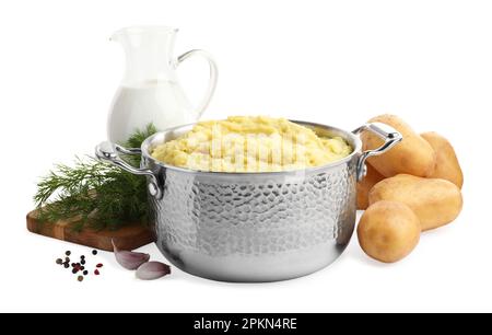 Pot de purée de pommes de terre savoureuse près des ingrédients sur fond blanc Banque D'Images