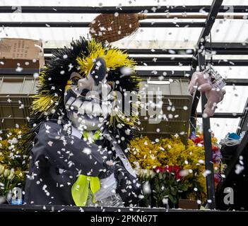 Costume de Waggis à l'intérieur d'un char de parade jetant des confetti au carnaval de Basel Fasnacht en Suisse Banque D'Images