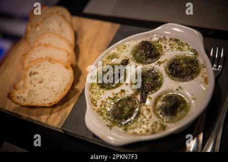 Escargot cuit avec du pain et des ustensiles Banque D'Images