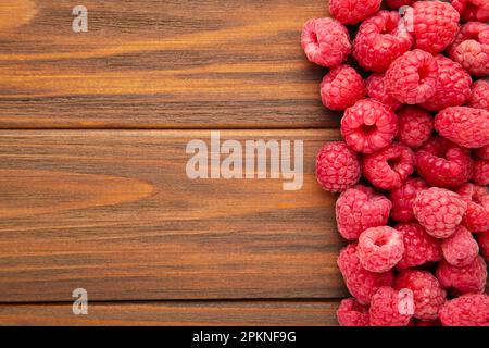 Framboises mûres sur fond de bois brun avec espace de copie. Vue de dessus Banque D'Images