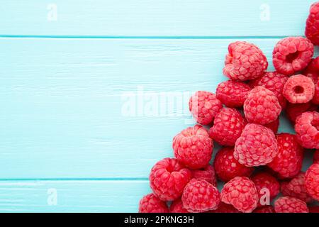 Framboises mûres sur fond en bois bleu avec espace de copie. Vue de dessus Banque D'Images