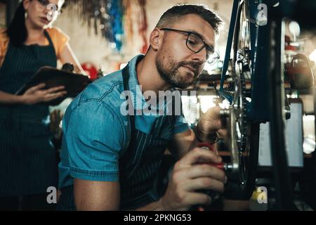 La meilleure mécanique de vélo de la ville. un homme et une femme travaillant ensemble dans un atelier de réparation de vélos. Banque D'Images