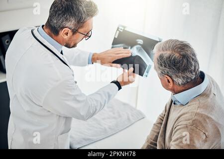 Heres pourquoi ce genou vous a dérangés. un médecin et son patient mature regardant une radiographie ensemble pendant une consultation. Banque D'Images