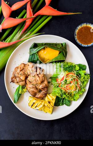 Poulet vietnamien, pattes désossées, petit maïs au fromage, salade et ananas grillé Banque D'Images