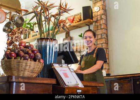 Bonne serveuse vietnamienne travaillant dans une cuisine d'un café Banque D'Images