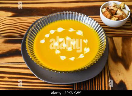 Soupe de citrouille sur table en bois avec crackers vue latérale Banque D'Images