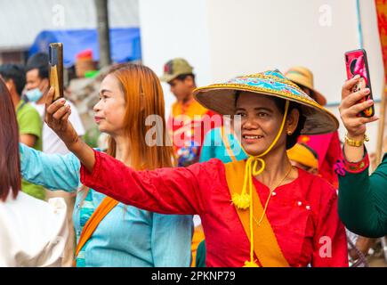 PAI,Nord de la Thaïlande-4 avril 2023:femmes Prenez des photos de la procession de rue de passage, assisté par des centaines de thaïlandais, où les garçons sont ordonnés à être Banque D'Images