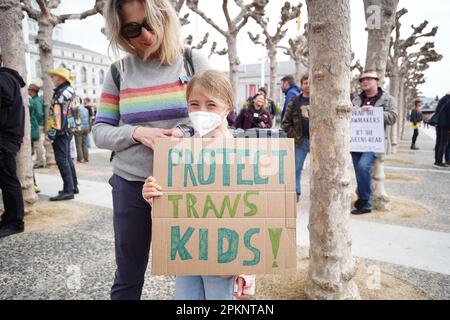 Un enfant porte un écriteau indiquant « Protégez les enfants trans! » pendant la démonstration. « Faites glisser ! Combattez ! » march tient par quelques organisations LGBTQ à San Francisco. Les objectifs de la marche protestent contre la vague croissante de législation anti-traîner et anti-LGBTQ dans toute l'Amérique. Les gens marchent de l'hôtel de ville de San Francisco à Union Square avec des pancartes, des bannières et des drapeaux arc-en-ciel. Les pancartes que les gens utilisent pendant la marche ont écrit « Protect Trans Kids », « Ban guns not Drug », « Drag the législateurs », « Drag is Freedom » et bien plus encore. Banque D'Images