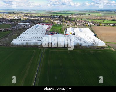 Vue de drone d'un grand entrepôt de logistique et de distribution vu niché dans la campagne de l'Anglian est. Le terrain plat des fens est évident. Banque D'Images