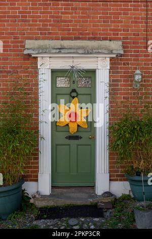 Porte d'une maison dans le village de Hambledon en Angleterre, fait à la main décoration d'un tournesol dans le centre. Avril 2023 Banque D'Images