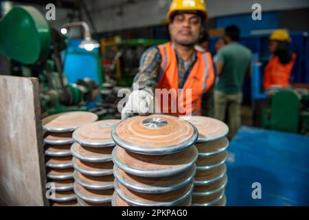 Meerut, Inde. 08th avril 2023. Un travailleur a vu arranger une pile de disque de discus en bois à l'usine Nelco India Pvt. Ltd, une usine de fabrication d'équipements de piste et de terrain. Meerut est l'un des principaux centres du pays pour la fabrication de produits sportifs. Crédit : SOPA Images Limited/Alamy Live News Banque D'Images