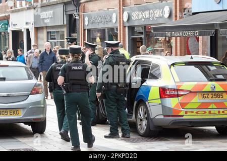 Service de police PSNI d'Irlande du Nord, hommes et femmes, patrouille skoda dans une zone piétonne très fréquentée sur appel en raison de la conduite de la voiture dans un piéton Banque D'Images