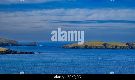 La côte Shetland au point de vue de la plage de Rerwick avec un petit bateau de pêche au premier plan Banque D'Images