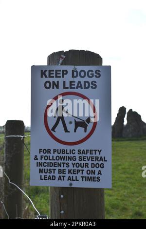 Un avis sur un poteau de clôture: 'Garder les chiens sur les pistes'. Banque D'Images