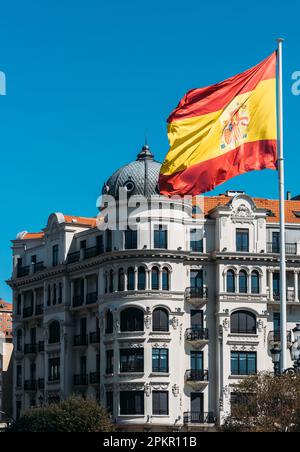 Drapeau de l'Espagne sur un grand mât de la Plaza Matias Montero à Santander, Cantabrie, Espagne avec l'architecture traditionnelle du 19th siècle en arrière-plan Banque D'Images