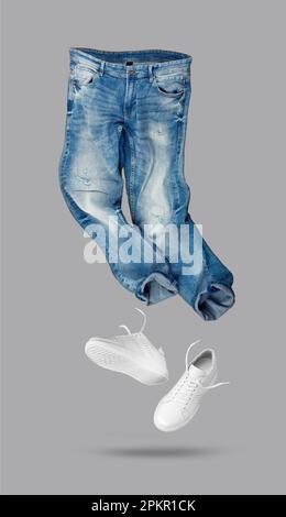 Jeans bleus, baskets en cuir blanc isolées sur fond gris. Vêtements de marque. Créez un modèle pour votre style. Avec masque. Banque D'Images