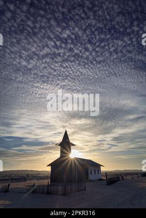 Le soleil se couche sur la rivière Kuiseb et une petite église de la Mission rhénane près de la colonie de Rooibank. Banque D'Images