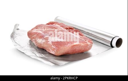 Rouleau de papier d'aluminium avec morceau de viande crue sur fond blanc Banque D'Images