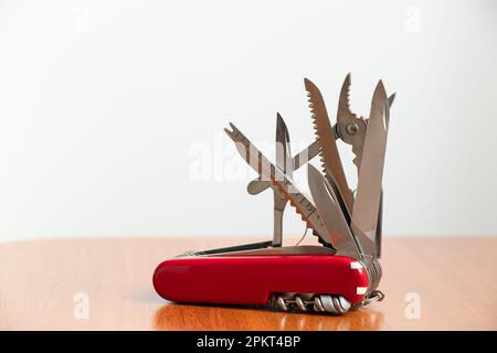 Couteau multifonction sur table en bois et fond blanc Banque D'Images