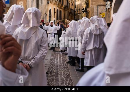 La chorale de fraternité chante des chansons religieuses pendant la procession de Pâques à travers les rues de la vieille ville de Cagliari Banque D'Images