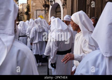 La chorale de fraternité chante des chansons religieuses pendant la procession de Pâques à travers les rues de la vieille ville de Cagliari Banque D'Images