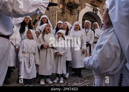 La chorale de fraternité chante des chansons religieuses pendant la procession de Pâques à travers les rues de la vieille ville de Cagliari Banque D'Images