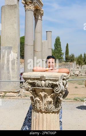 La femme pose près de l'ancienne colonne de l'ordre Corinthien dans les ruines d'Éphèse, en Turquie. Banque D'Images