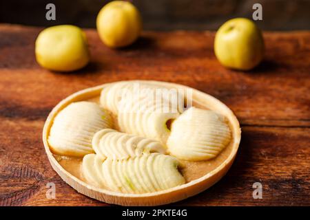 Tarte aux pommes congelée. Pommes en sauce caramel en aluminium sur fond de bois. Banque D'Images